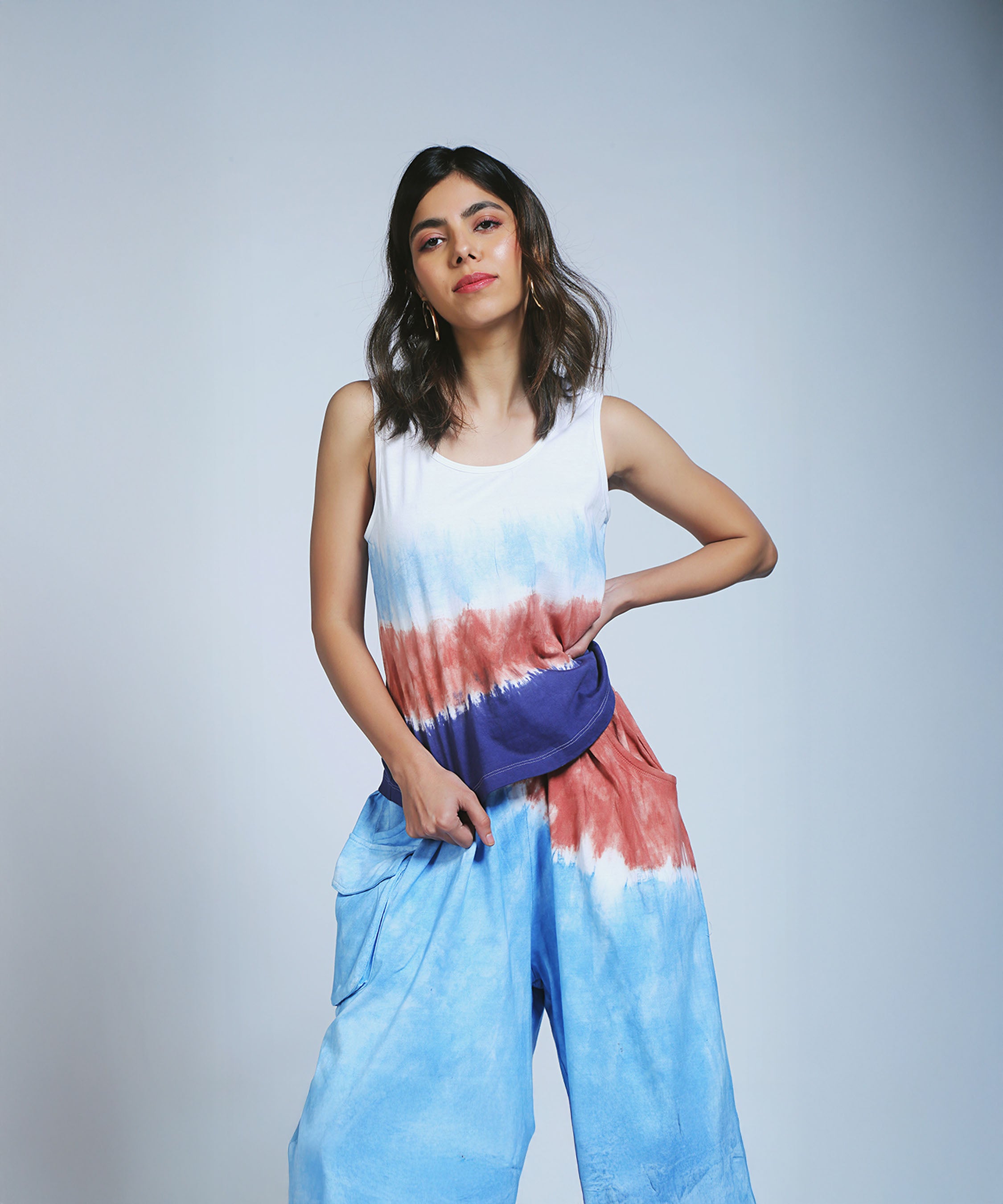 Woman in Cargo Pocket Parallels and a Comfort Fit Tank Top poses with one hand on her hip against a plain light background.