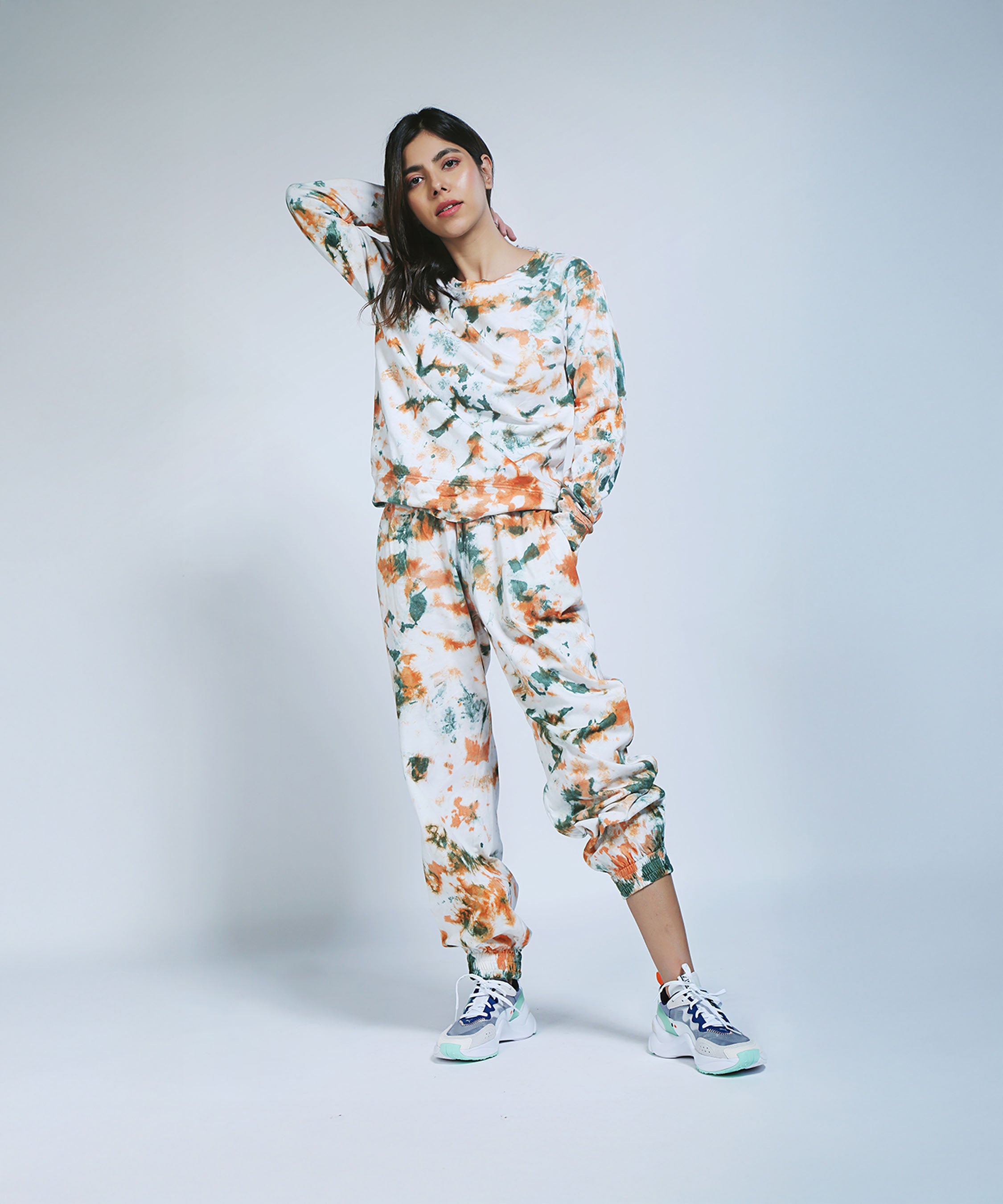 Model in the Earthy Tones Sweatshirt / Tee and Comfort Joggers, posing with one hand on her head against a plain background.