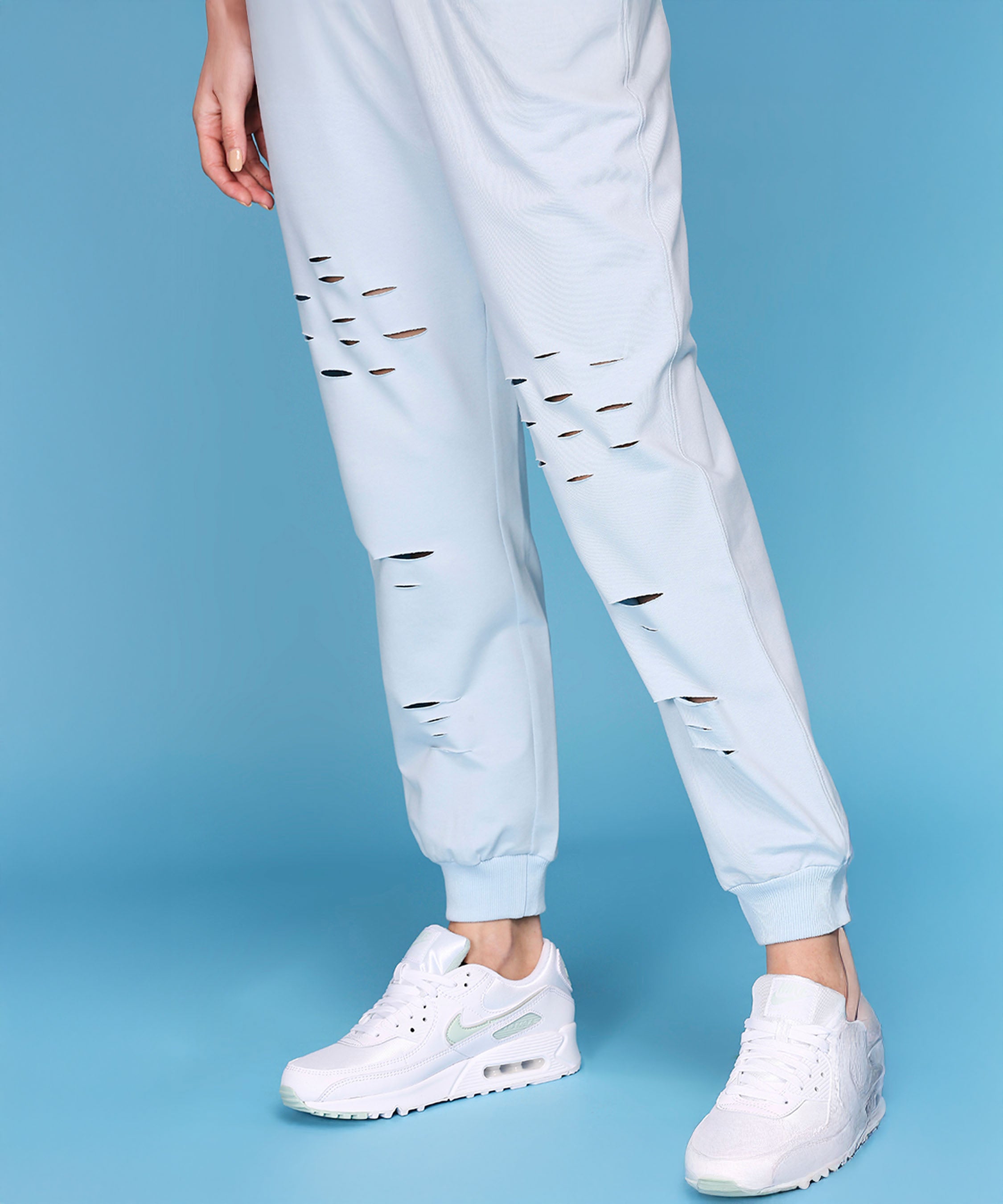 A person wearing Off Shoulder White Rib/Light Blue Ripped Joggers AW21.