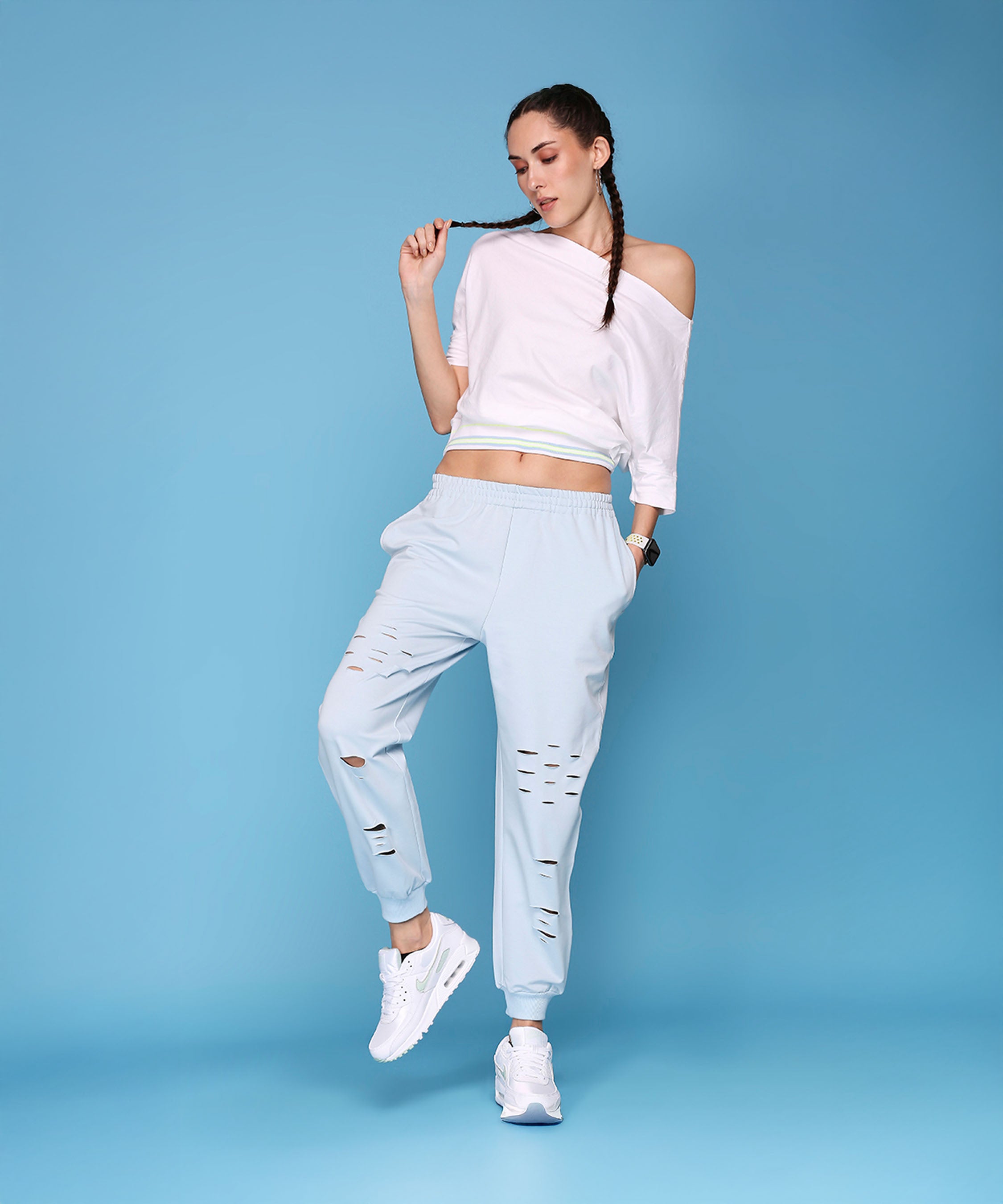 A woman wearing Off Shoulder White Rib and Light Blue Ripped Joggers AW21.