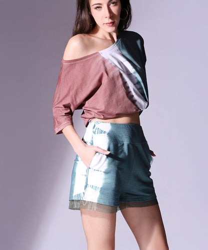 Woman wearing the Oversized Comfort Tee + Shorts - AW21 set, featuring an off-shoulder top and matching dip dyed shorts with pockets, posing against a plain background.