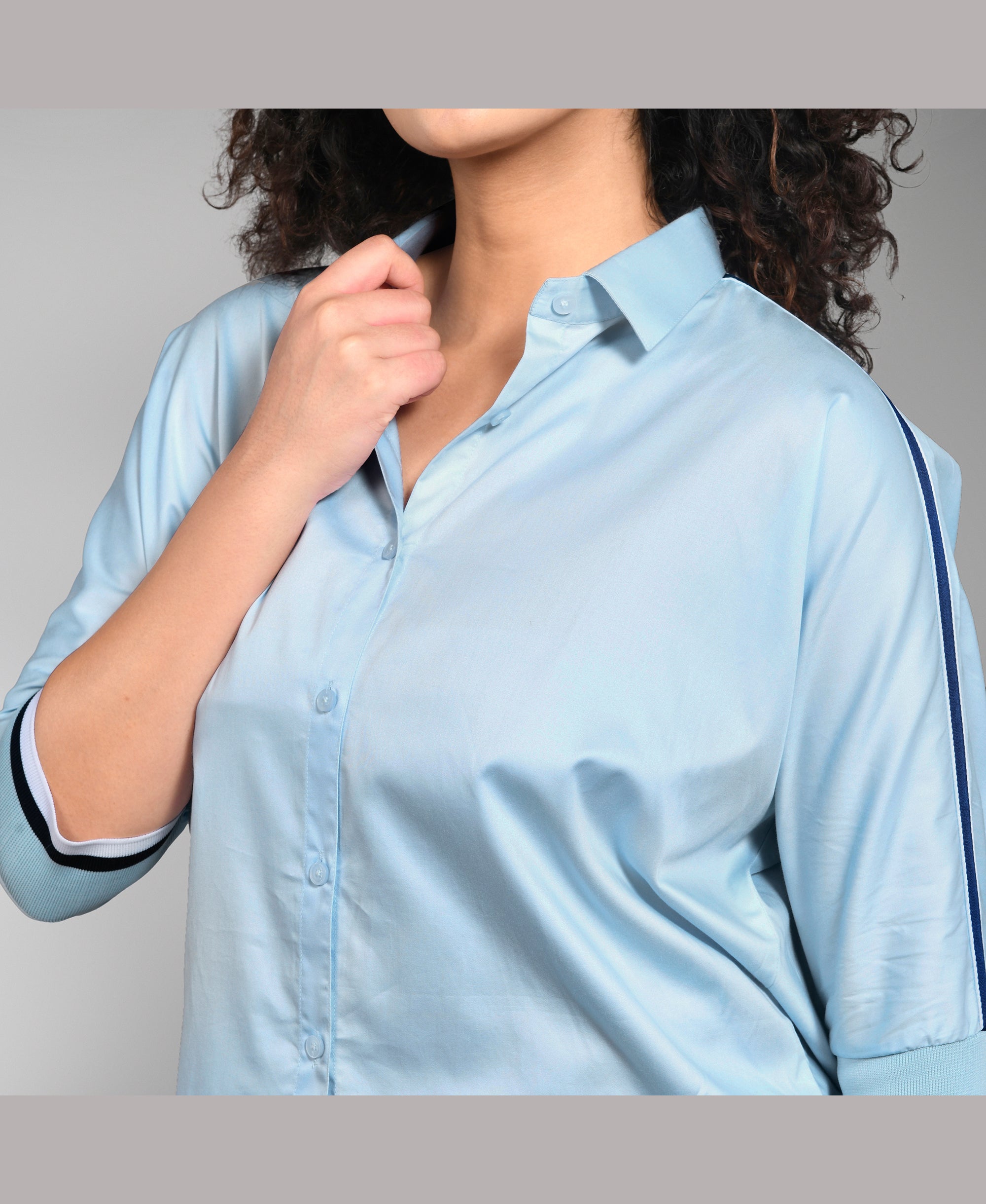 Model wears the Denim Chic Set—a light blue button-up shirt with rolled sleeves, styled with cargo track pants—for an easygoing yet chic look.