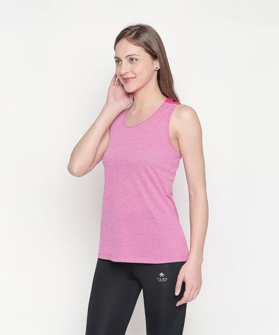 Woman wearing a Pink Sleeveless Tank Top and black leggings stands against a white background, smiling.