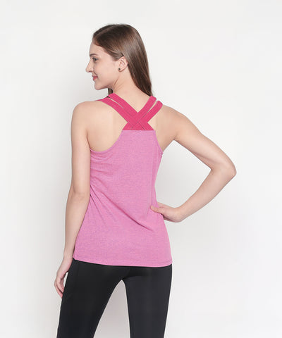 Woman wearing a Pink Sleeveless Tank Top with crisscross straps, shown from the back, paired with black pants.