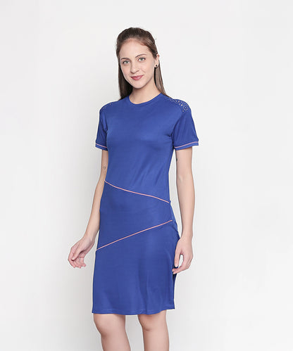 A woman stands against a plain white background wearing the Half Sleeve Royal Blue Round Neck Dress, featuring pink accents, a regular fit, and short sleeves.
