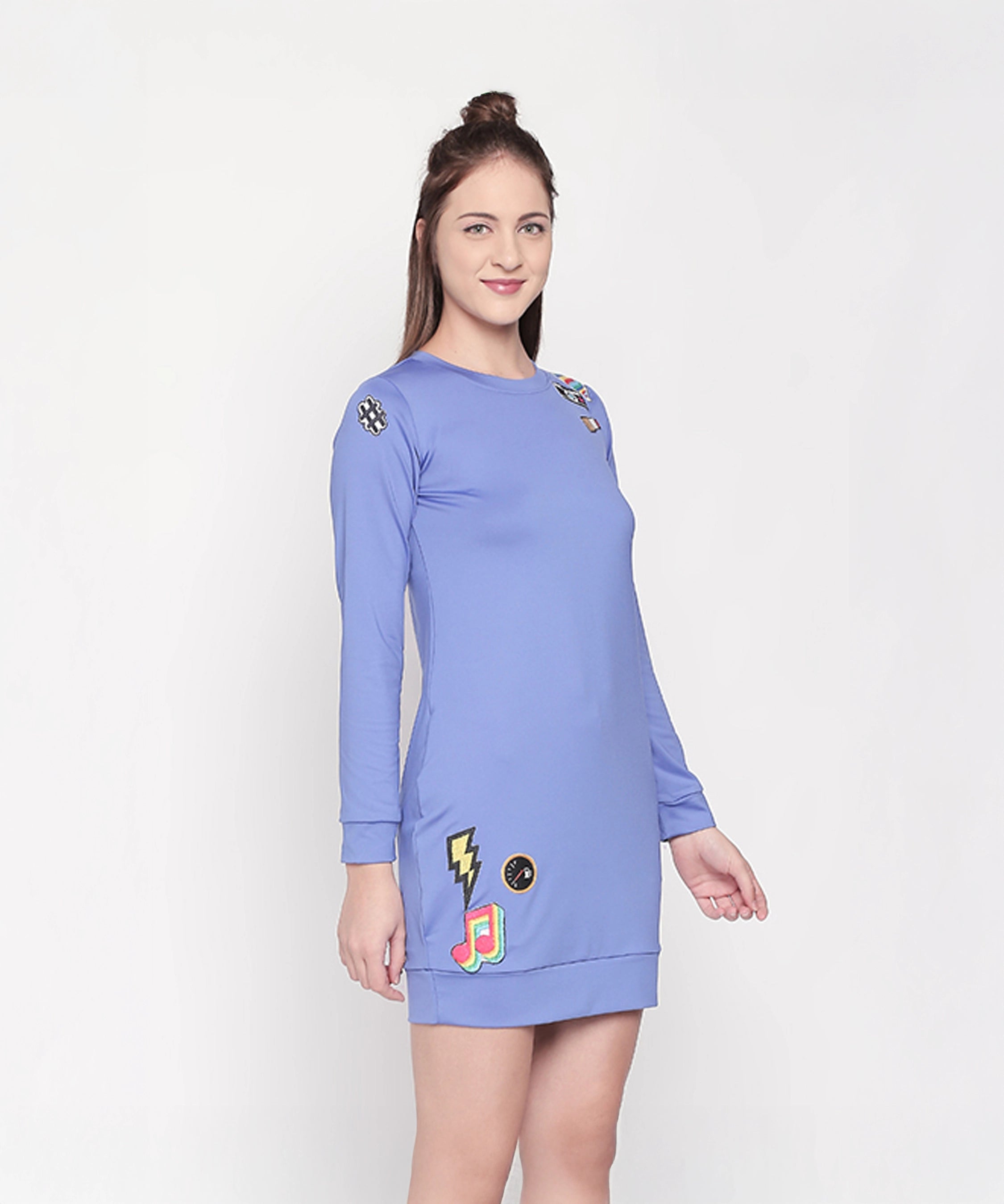 Woman wearing the Cool Patched Full Sleeve Blue Dress from Tuna London, featuring colorful patches, standing against a plain background.