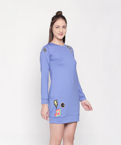 Woman wearing the Cool Patched Full Sleeve Blue Dress from Tuna London, featuring colorful patches, standing against a plain background.
