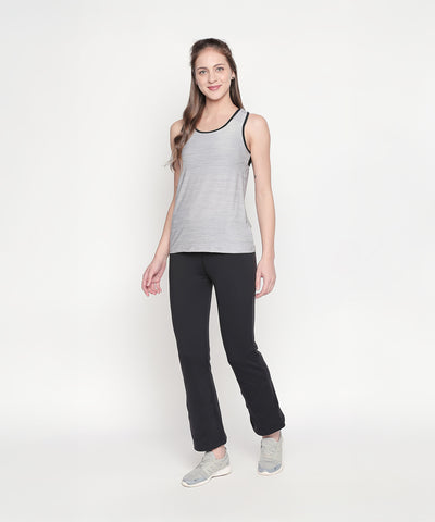 A woman in a gray tank top and Bootcut High Waisted Workout Pants stands against a plain white background, wearing gray sneakers.
