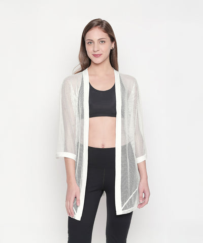 Model styling the Loose Fit 3/4th Sleeve White Shrug for Women over a black crop top and pants, set against a white background for an easy athleisure look.