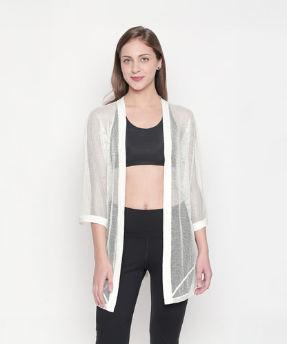 Model styling the Loose Fit 3/4th Sleeve White Shrug for Women over a black crop top and pants, set against a white background for an easy athleisure look.