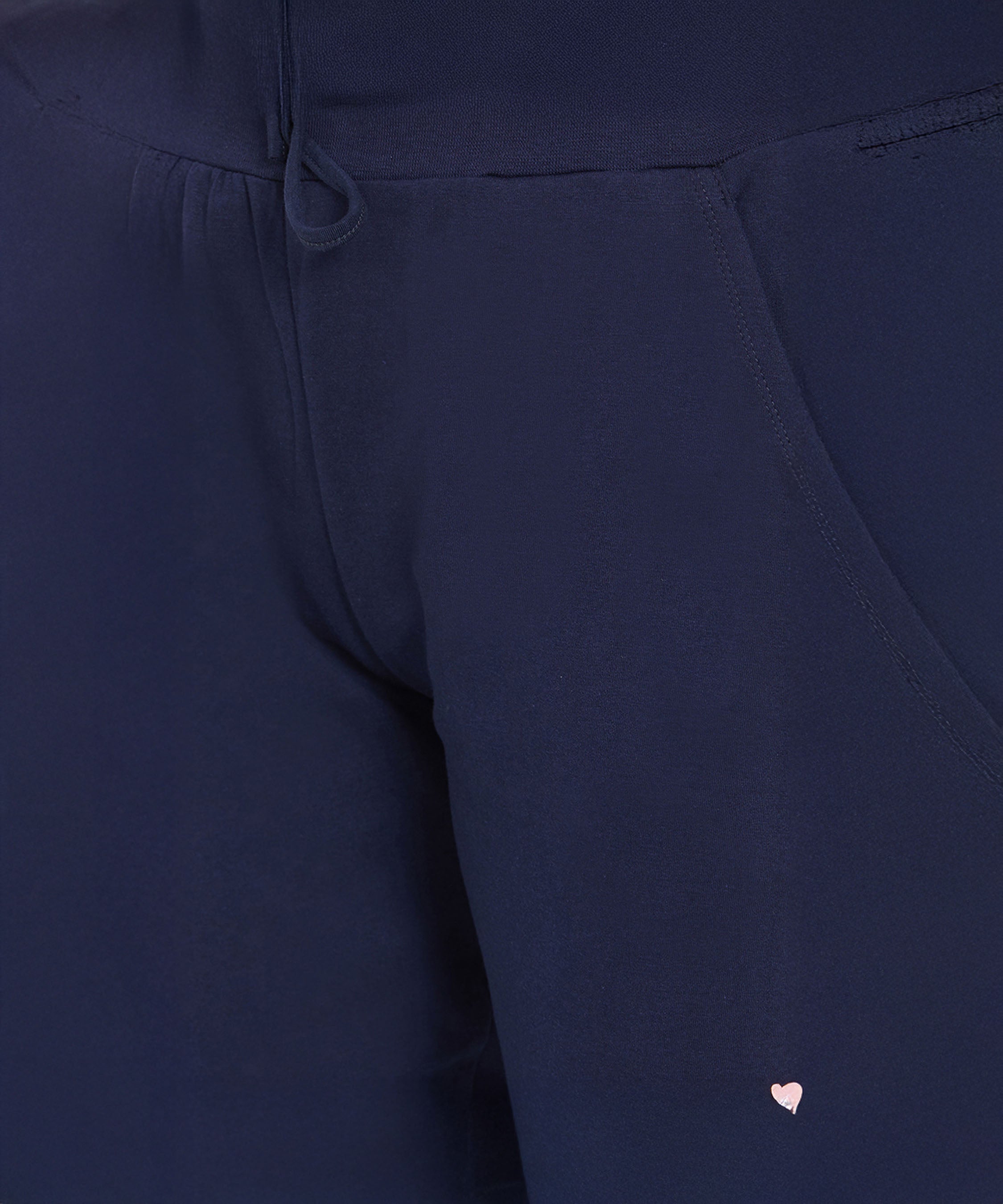 Close-up of Ashtanga Series Blue Joggers featuring a navy blue design and a small pink heart detail near the pocket.