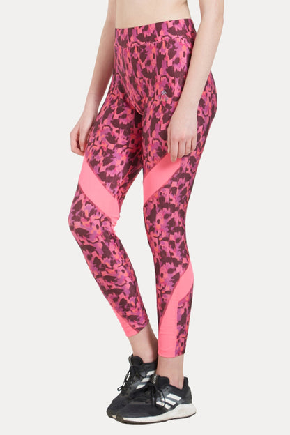 Woman wearing Printed Slim Fit Track Pant LUSH by TUNA LONDON, crafted from comfy poly spandex in pink, paired with black sneakers, standing against a plain light background.
