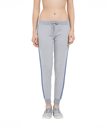 A woman wearing Side Stripe Joggers TLC03SS with blue side stripes and gray sneakers stands against a white background.