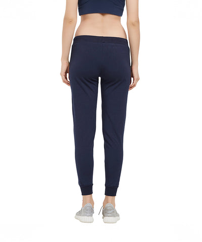 Woman wearing Side Stripe Joggers TLC04SS in navy, regular fit, cotton, paired with sneakers; shown from the back against a plain white background.