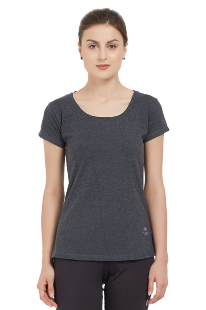 Woman wearing a Grey Round Neck Tee by TUNA LONDON and black pants, standing against a white background. The moisture-wicking fabric offers all-day comfort and style.