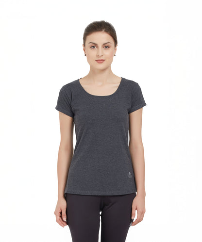 Woman wearing a TUNA LONDON Grey Round Neck Tee and black pants, standing against a white background.