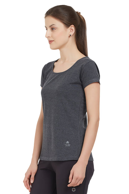 Woman in a Grey Round Neck Tee and black pants stands sideways, looking forward. The moisture-wicking fabric of the tee ensures comfort throughout the day.