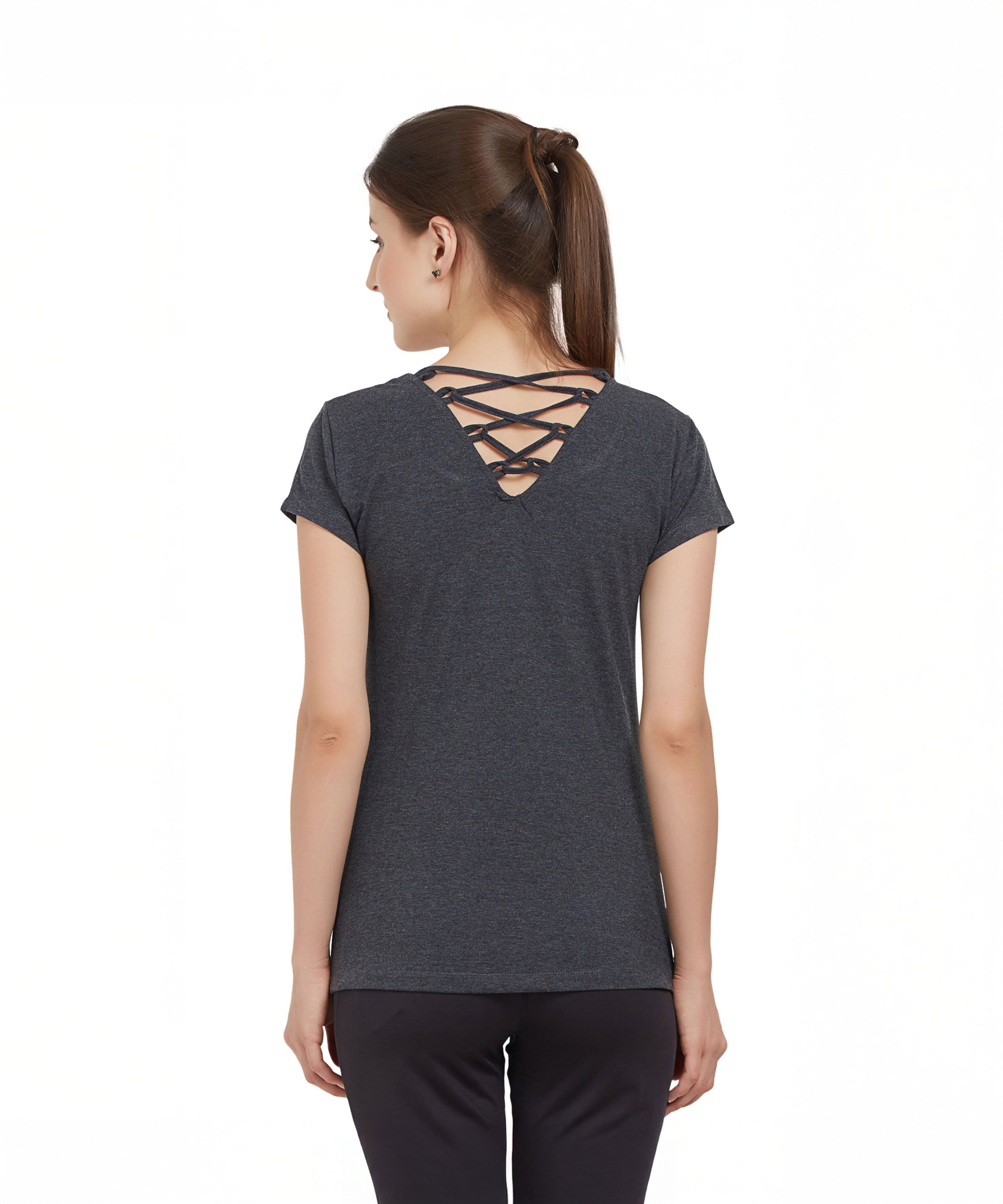 Woman with brown hair in a ponytail wears a TUNA LONDON Grey Round Neck Tee made from cotton lycra, featuring a stylish crisscross back detail, facing away.