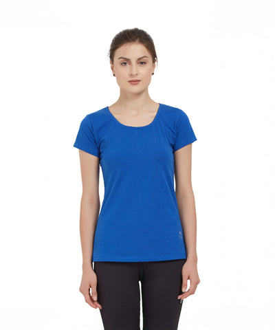 A woman wears a Royal Blue Round Neck Tee and black pants, standing against a white background.
