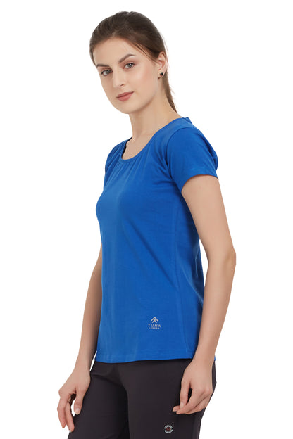 Woman wearing a Royal Blue Round Neck Tee with moisture-wicking fabric and black pants, standing against a white background.