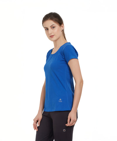Woman in a Royal Blue Round Neck Tee and black pants stands against a plain white background, facing slightly sideways.
