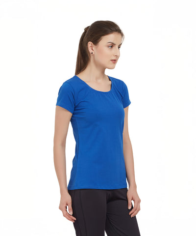 Woman in a Royal Blue Round Neck Tee and black pants stands sideways against a plain white background.