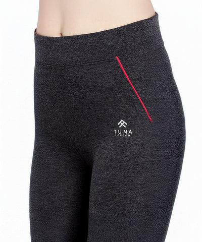 Close-up of a person wearing Classic Capri TLC67GRY—dark gray high-waisted yoga capris with a red accent and "Tuna London" logo, made from soft heathered fabric.