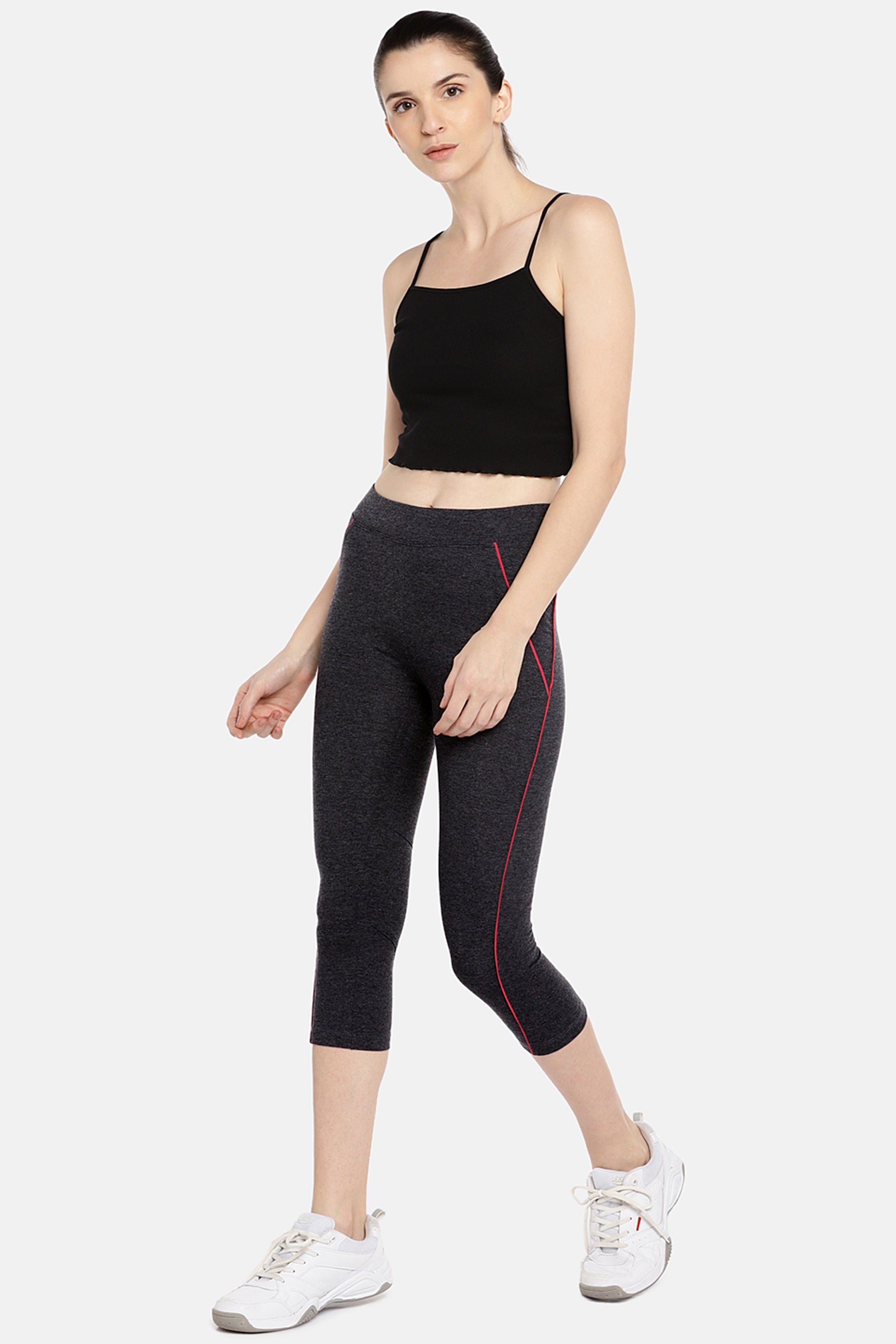 Woman in black crop top, Classic Capri TLC67GRY made from Cotton Spandex fabric, and white sneakers walking against a plain background—ideal for everyday workouts.