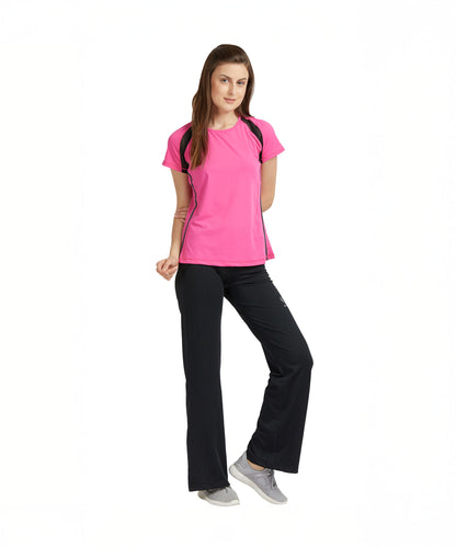 A woman poses confidently against a white background, wearing the Tuna London Pink Poly Blend Round Neck Women’s T-Shirt and black workout pants, styled for the gym.