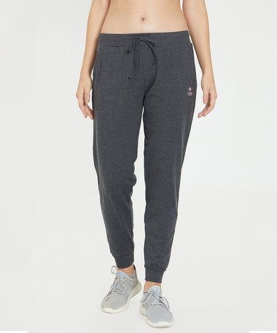 A woman wearing Classic Joggers 81, featuring a slim tapered fit, paired with light grey sneakers stands against a plain white background.