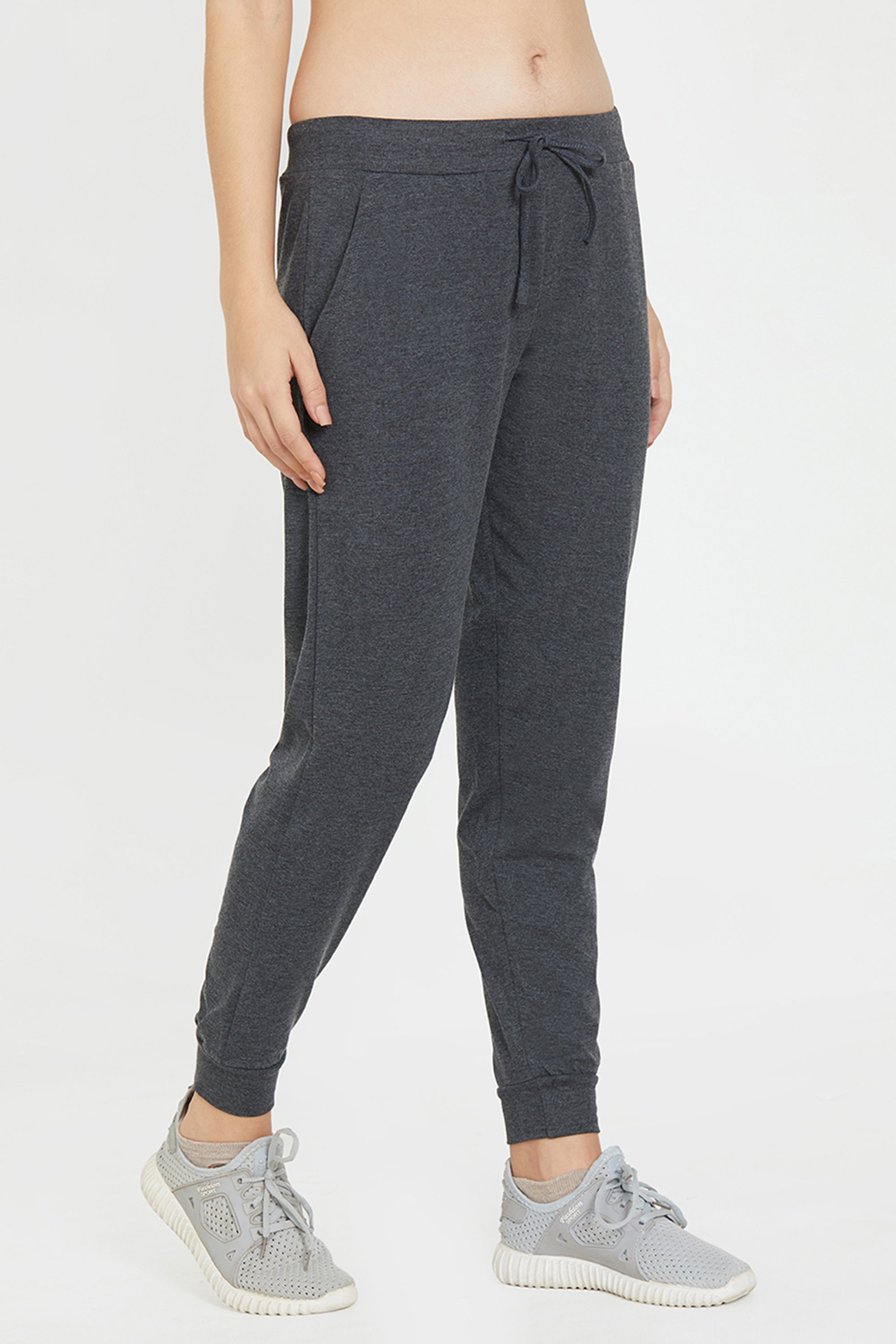 Wearing Classic Joggers 81 in dark gray with light gray sneakers, standing against a plain light background—ideal for anyone who values lounge wear comfort and an adjustable fit.