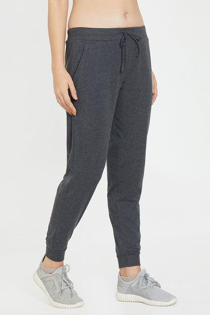 Wearing Classic Joggers 81 in dark gray with light gray sneakers, standing against a plain light background—ideal for anyone who values lounge wear comfort and an adjustable fit.