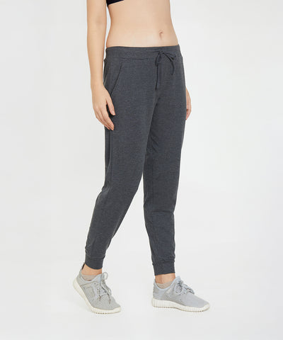 Person wearing Classic Joggers 81 with a slim tapered fit, paired with grey sneakers and a black crop top, standing against a white background.
