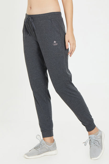 Model showcases Classic Joggers 81—dark jogger pants with an adjustable fit—paired with gray sneakers, pictured from torso to feet against a plain backdrop. Ideal choice for stylish lounge wear.