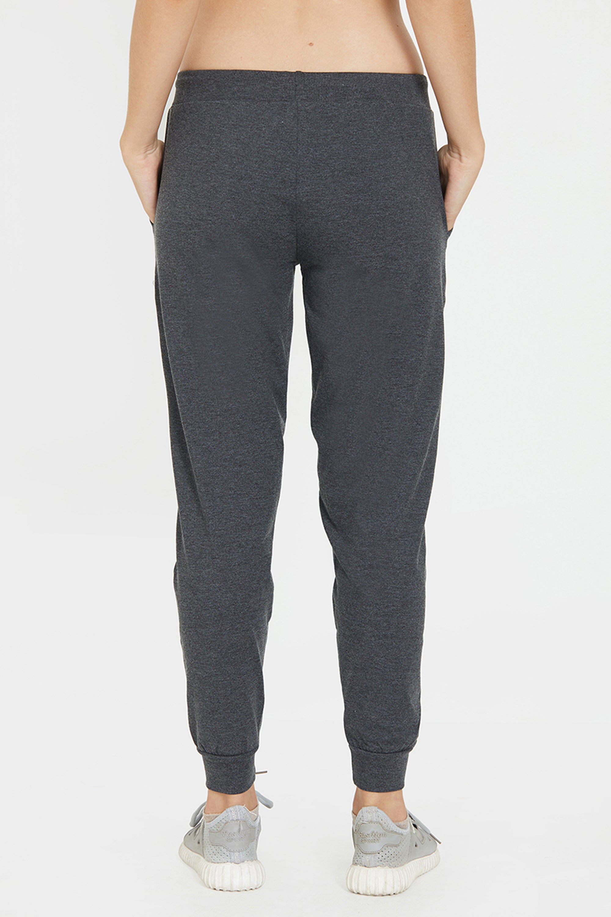 Model wearing Classic Joggers 81 in dark gray with an adjustable fit and light gray sneakers, shown from the back against a white background—ideal for stylish loungewear.