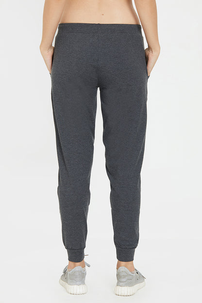 Model wearing Classic Joggers 81 in dark gray with an adjustable fit and light gray sneakers, shown from the back against a white background—ideal for stylish loungewear.