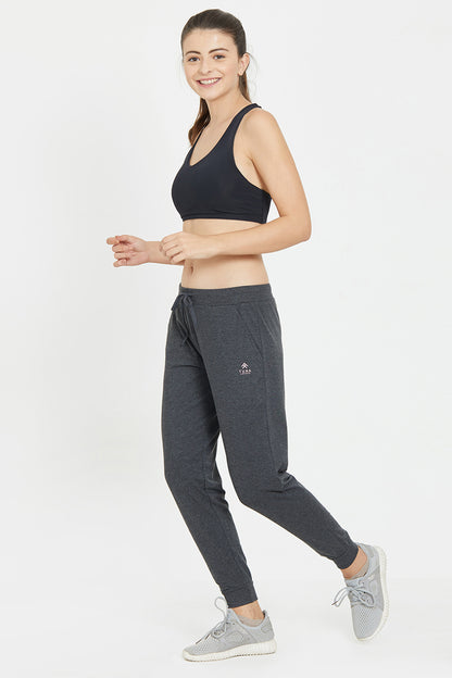 Smiling woman in a black sports bra and Classic Joggers 81 with an adjustable fit poses in a jogging stance against a white background—ideal for active days or relaxed lounging.