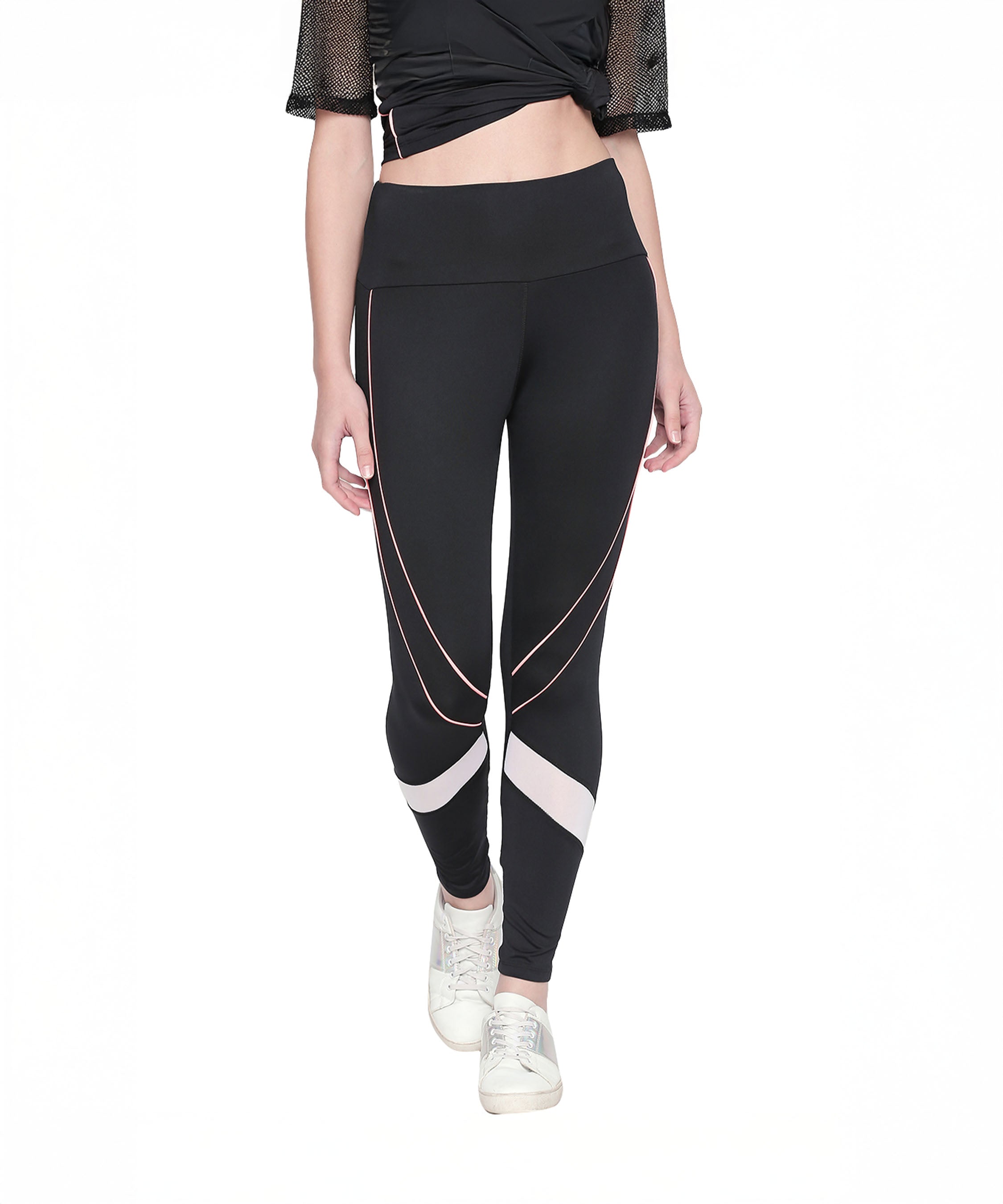 A woman models the Black High Waisted Leggings - G12, featuring white and pink geometric accents, paired with a black crop top and white sneakers against a white background.