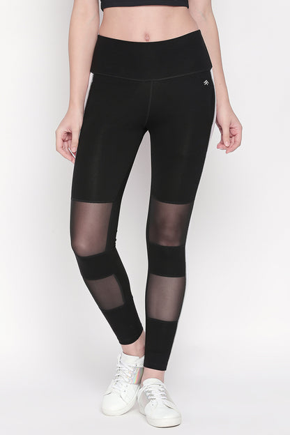 Woman wearing Black and White High Waisted Leggings - LG13 with white sneakers and a black crop top, standing upright.