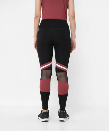 Model wearing Sienna Black High Waisted Leggings with red and white stripes, mesh panels, and four-way stretch, standing with back to camera.