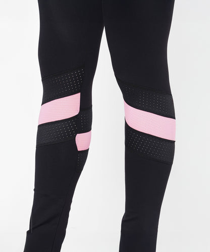 Model wears Black High Waisted Compression Legging With a Neon Pink Patch, featuring black mesh knee panels and four-way stretch compression fabric. Image shows leggings from mid-thigh down.