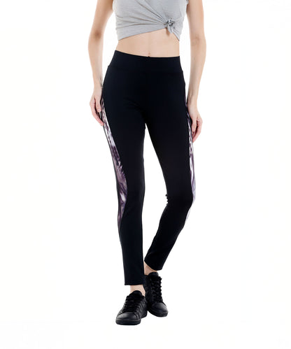 Woman in a gray crop top and Black Sports Leggings G2 featuring an elasticated waistband and side patterns, paired with black sneakers, standing against a white background.