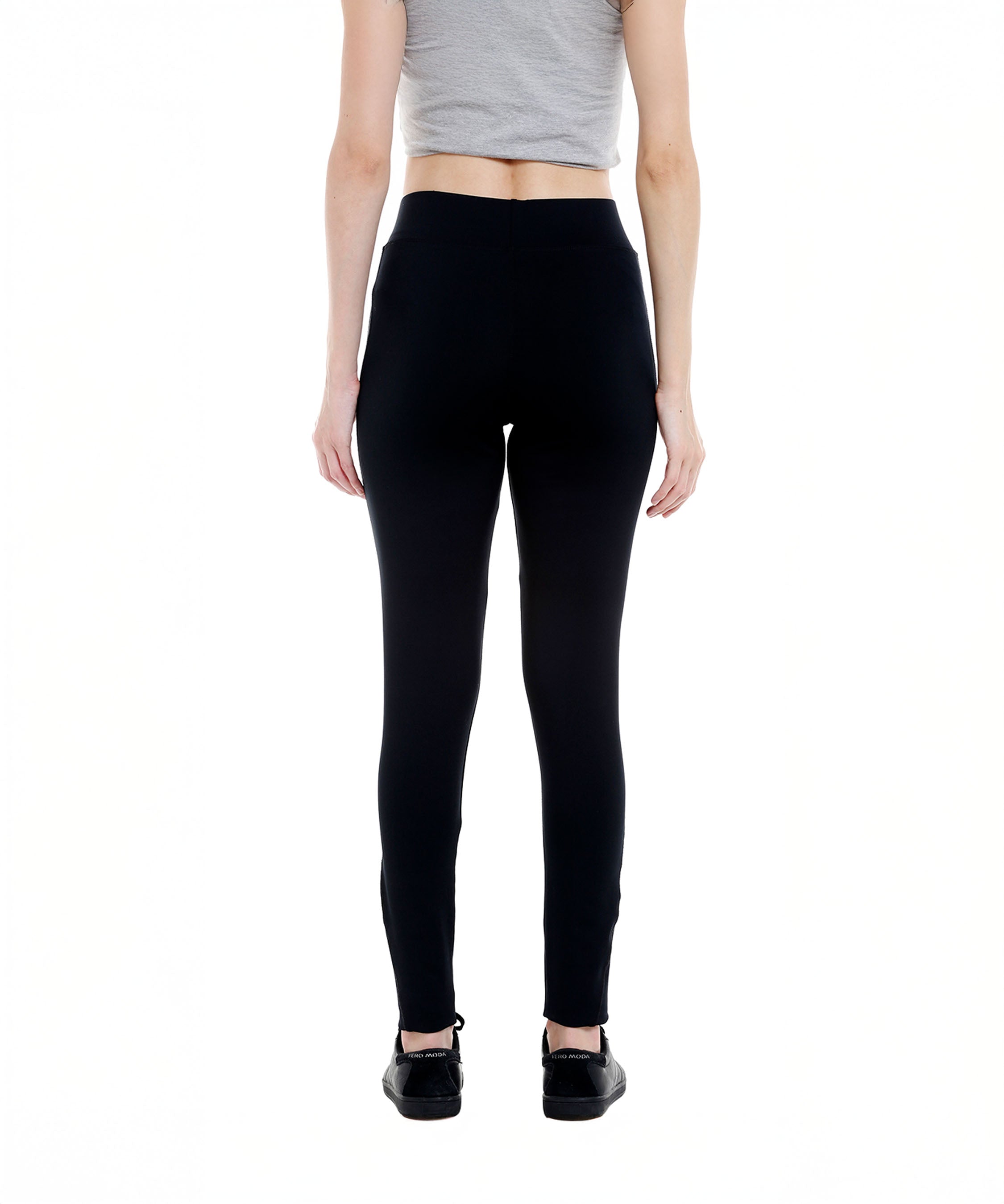 Person wearing a gray crop top and Black Sports Leggings G2 with an elasticated waistband, paired with black shoes, shown from the back on a white background.