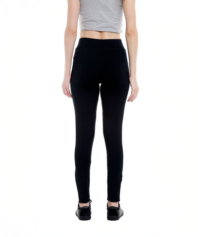 Person wearing a gray crop top and Black Sports Leggings G2 with an elasticated waistband, paired with black shoes, shown from the back on a white background.