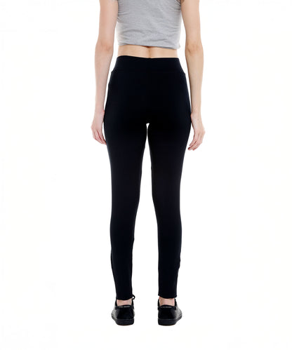 Person wearing a gray crop top and Black Sports Leggings G2 with an elasticated waistband, paired with black shoes, shown from the back on a white background.