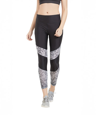 Woman wearing Women Tight Fit Polyester Sports Tights featuring a high-rise waistband and gray patterned panels, styled with a sports bra and gray sneakers, walking forward in comfort and style.