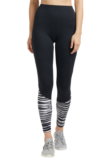 Woman wearing Black High Waisted Compression Sports Leggings With Zebra Print and gray athletic shoes, standing upright.