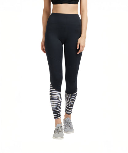 A woman wears Black High Waisted Compression Sports Leggings With Zebra Print, paired with grey sneakers and a black crop top.