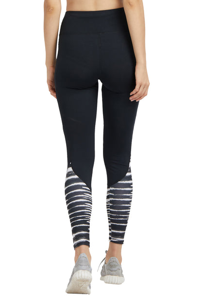 Woman wearing Black High Waisted Compression Sports Leggings With Zebra Print, standing with her back to the camera.