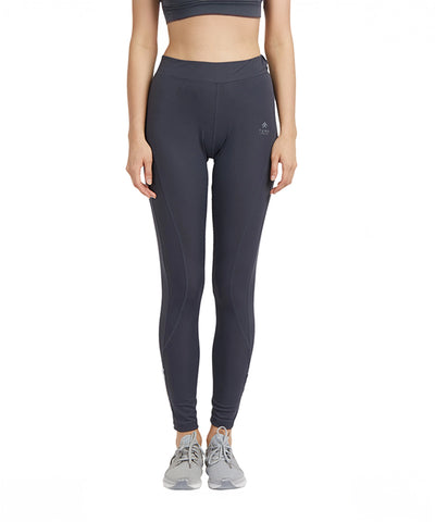 Woman wearing Grey High Waisted Sports Leggings G9, sports bra, and grey sneakers, standing against a white background.